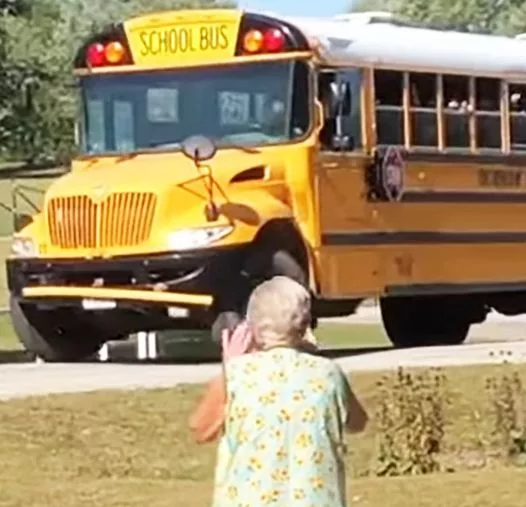 A school bus packed of kids stops for a little while to make grandma’s day.